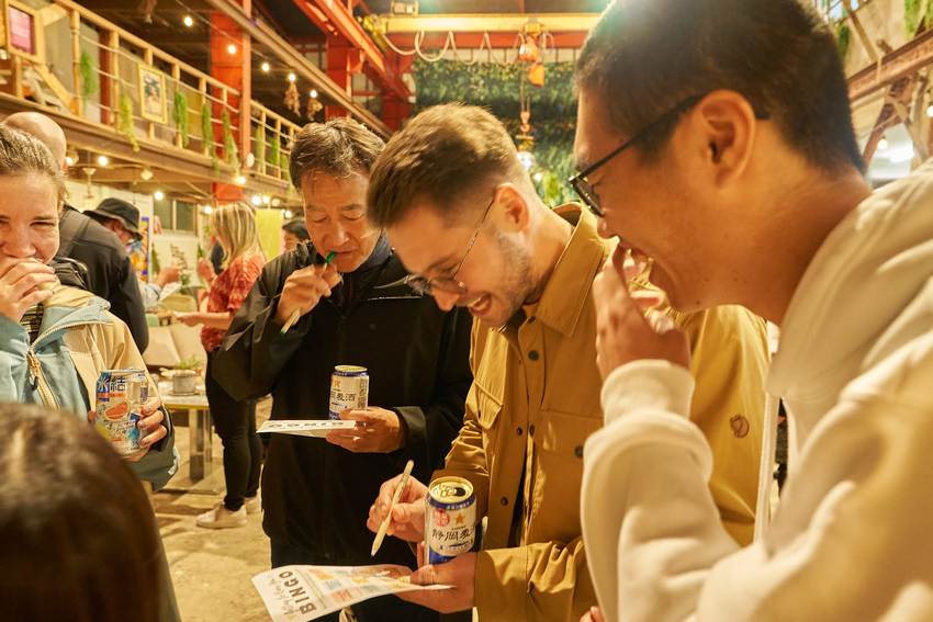 日本語話者と英語話者が一枚のシートを一緒に見ながら話している様子。