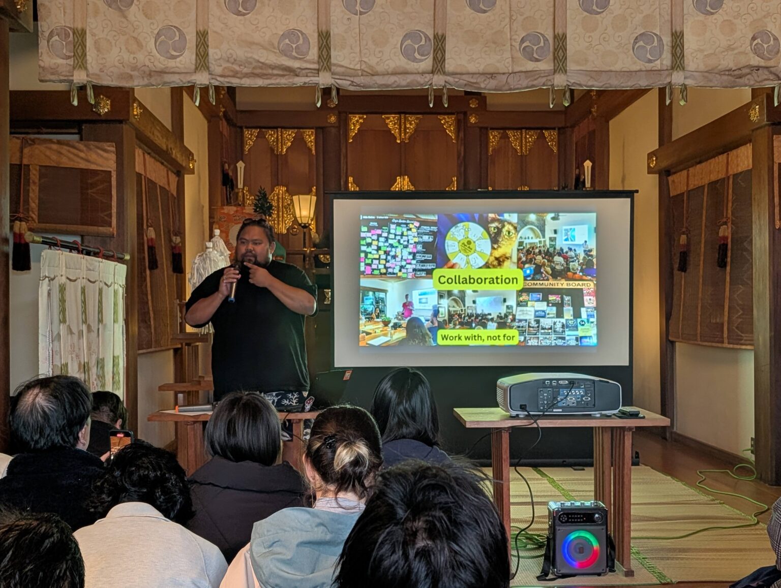 A speaker presenting to a seated audience at TADAIMA Mirai Kaigi