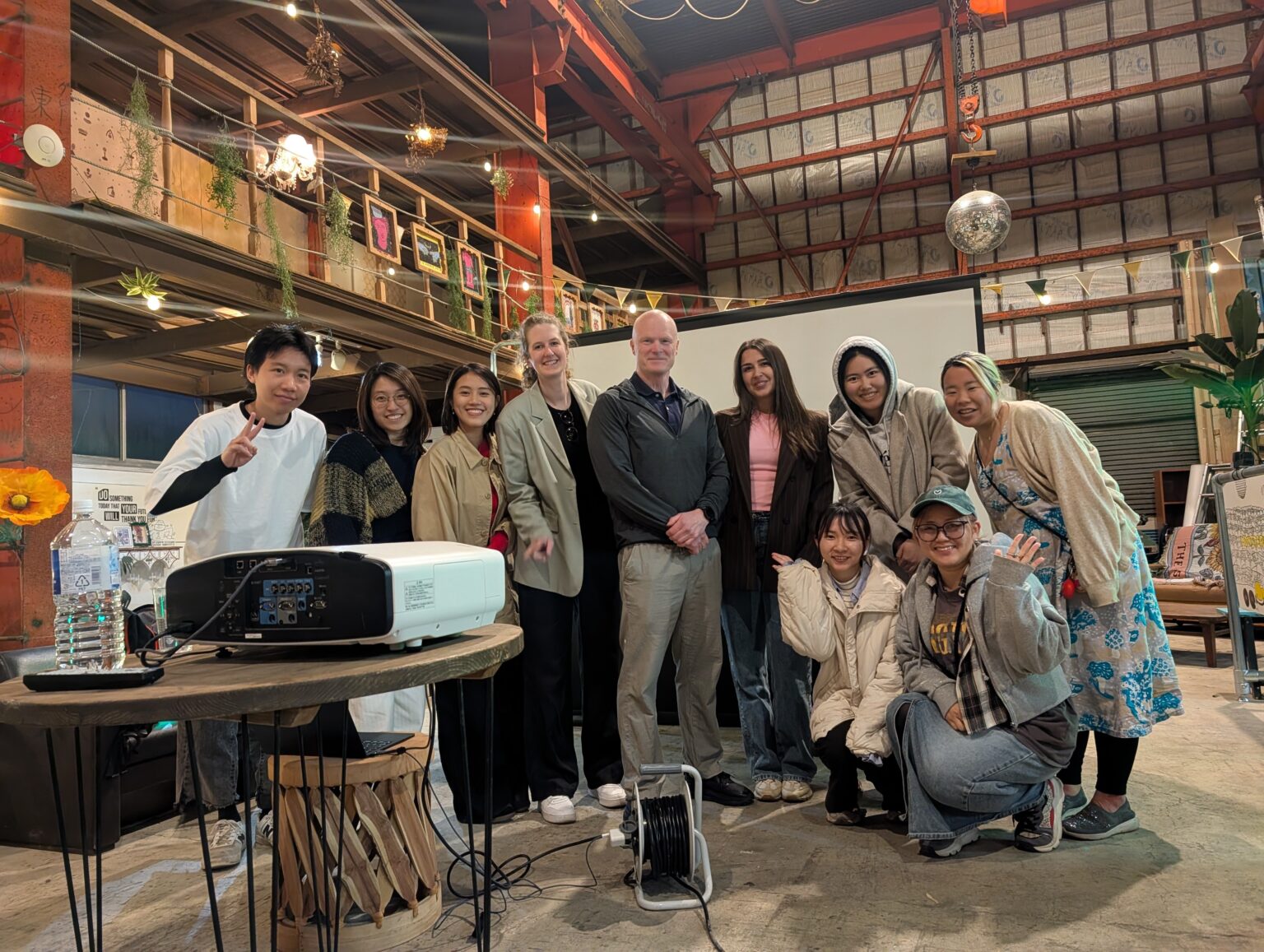 Tomas Nilsson with TADAIMA participants in front of a projection screen